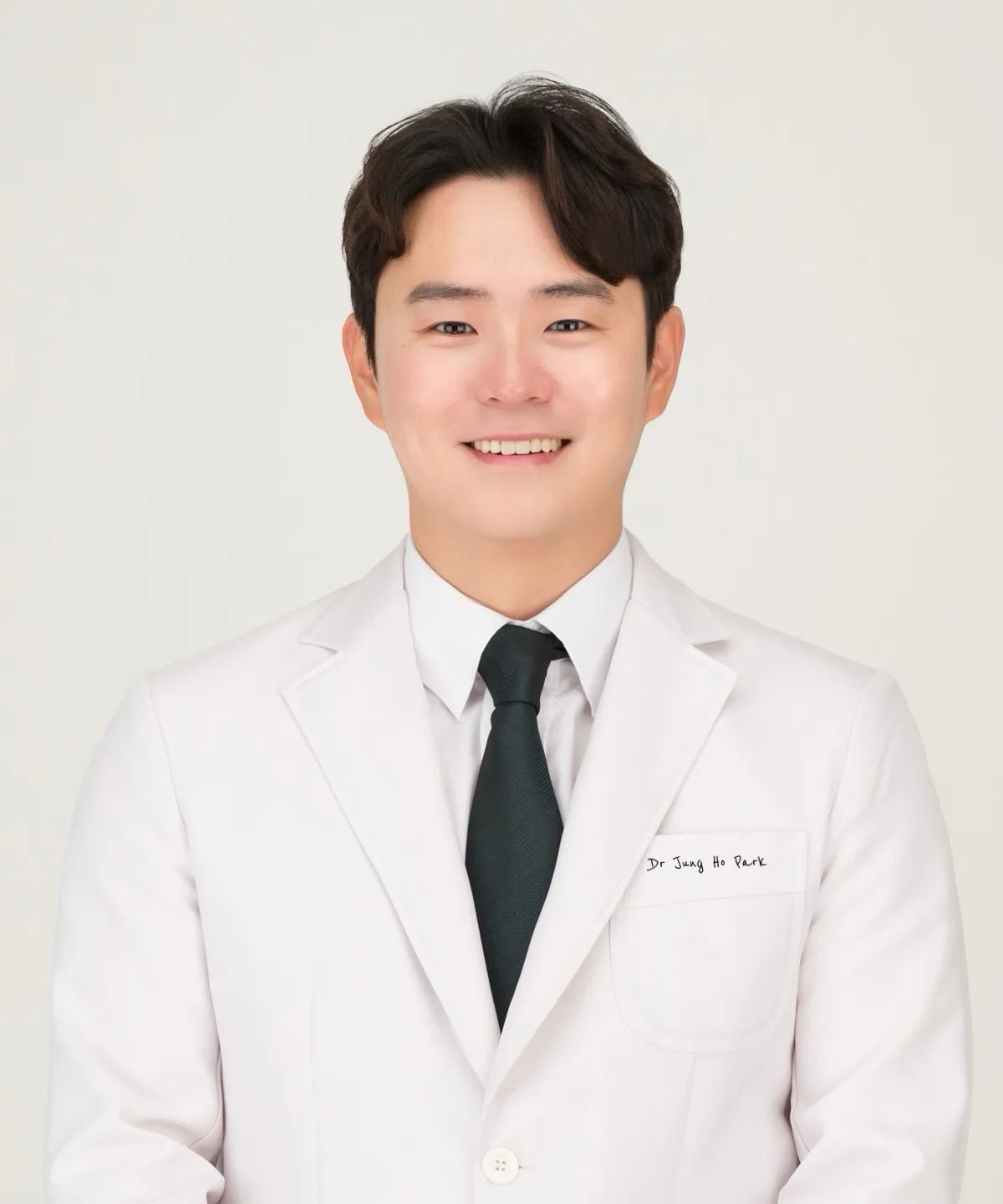 a man wearing a white jacket and black tie has the name dr. jung in park written on his chest