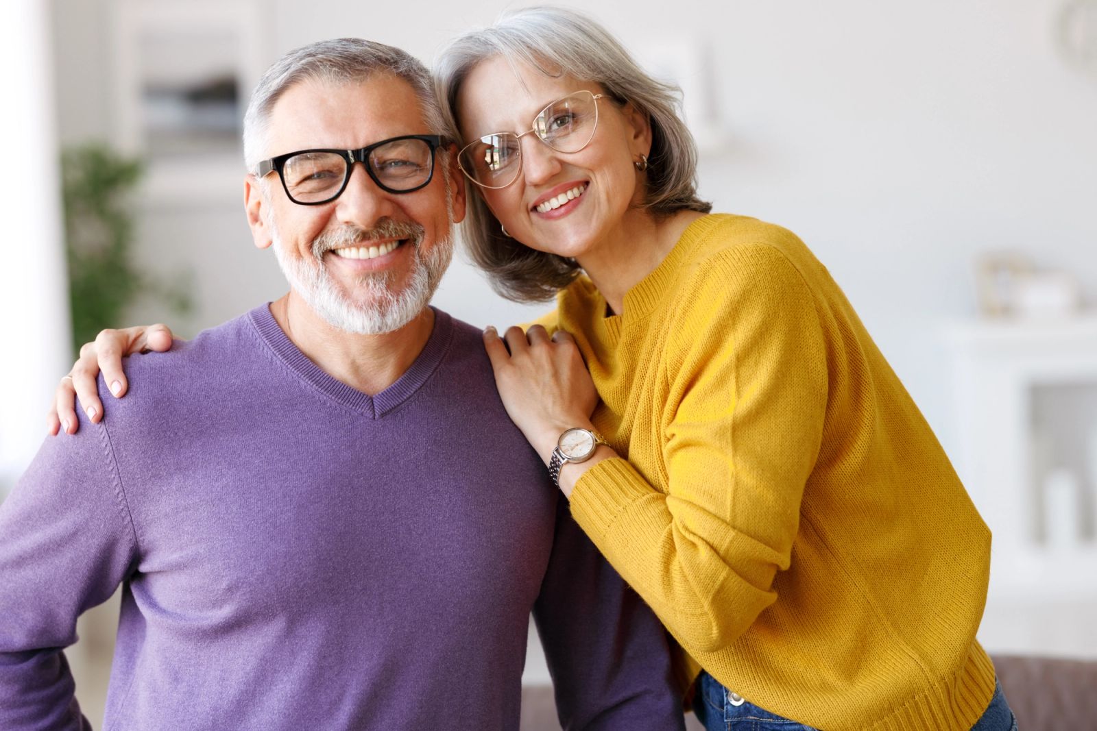 Smiling senior couple embracing and looking at the camera.